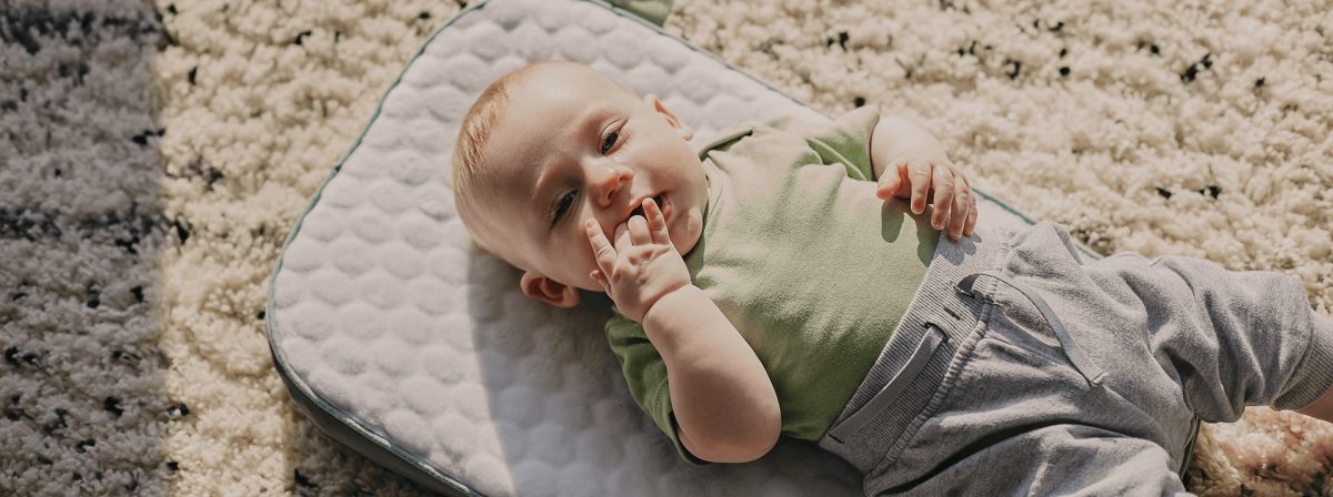 Em bé nằm chơi trên thảm, camera nghe được tiếng khóc